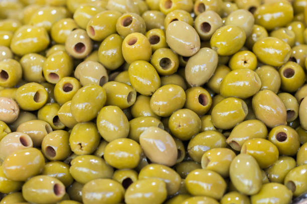 Green pitted olives closeup background of green olives street food market. Selective focus